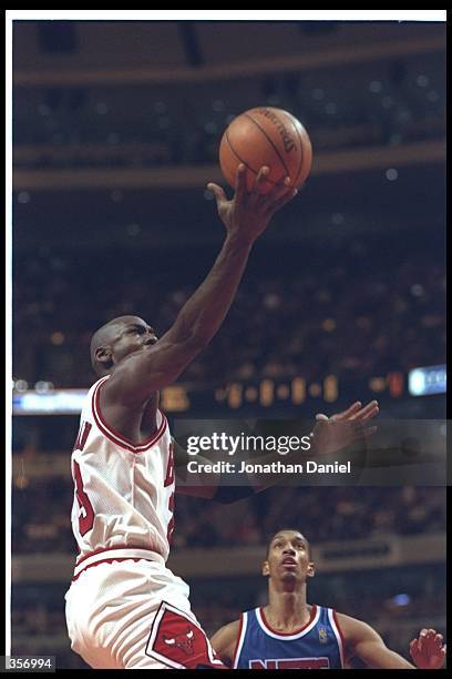 Guard Michael Jordan of the Chicago Bulls goes up for two as New Jersey Nets guard Kery Kittles looks on during a game at the United Center in...
