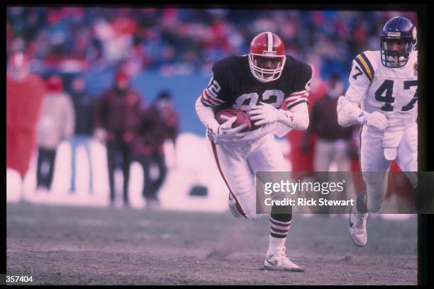 Tight end Ozzie Newsome of the Cleveland Browns runs with the ball as a Minnesota Vikings player chases him during a game at Cleveland Stadium in...