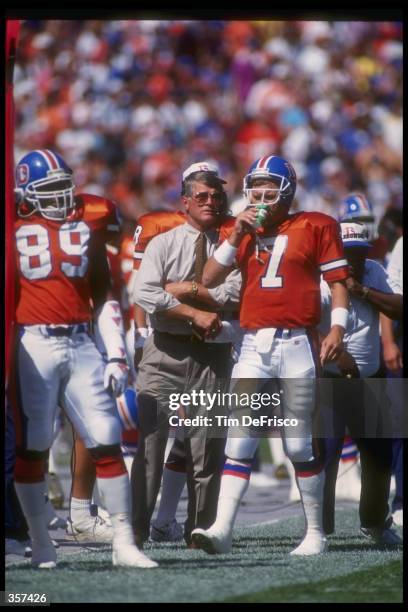Denver Broncos head coach Dan Reeves confers with quarterback John Elway during a game against the San Diego Chargers at Mile High Stadium in Denver,...
