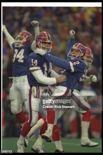 Quarterback Frank Reich of the Buffalo Bills celebrates with teammate kicker Steve Christie after a playoff game against the Houston Oilers at Rich...