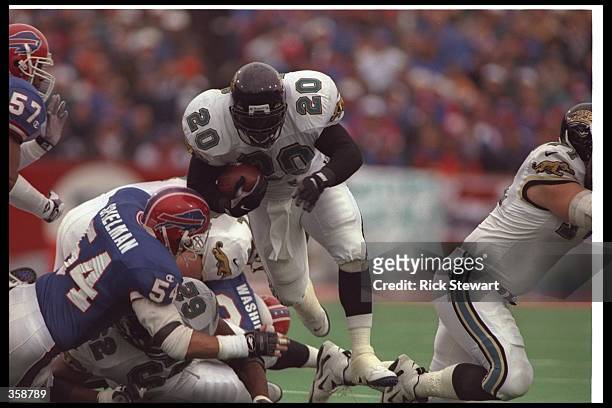 Running back Natrone Means of the Jacksonville Jaguars moves the ball during a playoff game against the Buffalo Bills at Rich Stadium in Orchard...
