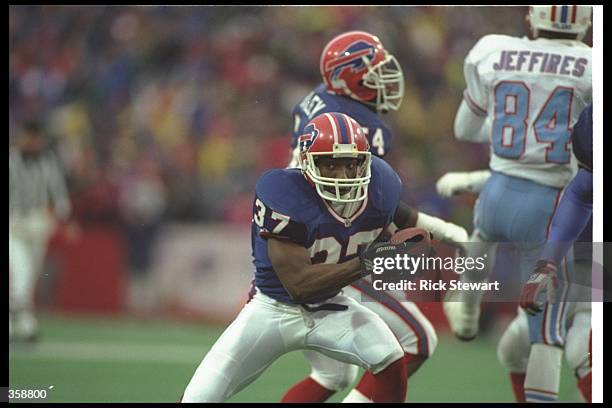 Defensive back Nate Odomes of the Buffalo Bills runs with the ball after making an interception during a playoff game against the Houston Oilers at...