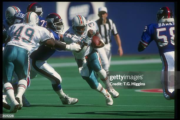 Running back Sammie Smith of the Miami Dolphins runs with the ball during a game against the New York Giants at Joe Robbie Stadium in Miami, Florida....
