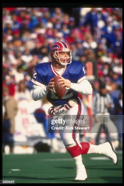 Quarterback Jim Kelly of the Buffalo Bills looks to pass the ball during a playoff game against the Denver Broncos at Rich Stadium in Orchard Park,...