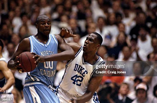 Elton Brand of the Duke Blue Devils tries to guard Brendan Haywood of the North Carolina Tar Heels at the Cameron Indoor Stadium in Durham, North...