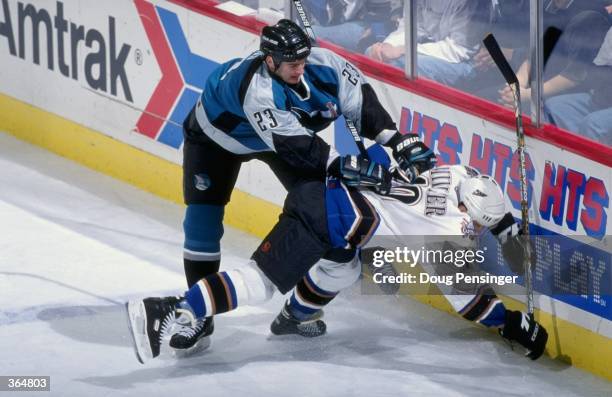 Shawn Heins of the San Jose Sharks slams Kelly Miller of the Washington Capitals into the wall face first, at the MCI Center in Washington D.C.. The...