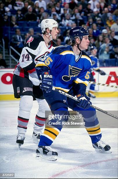 Jochen Hecht of the St. Louis Blues waits for the puck as Jay Makee guards him during the game against the Buffalo Sabres at the Marine Midland Arena...