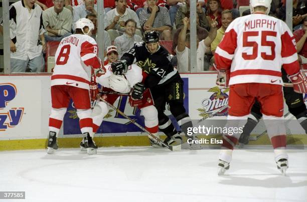 Guy Carbonneau of the Dallas Stars checks Viacheslav Fetisov of the Detroit Red Wings as Igor Larionov looks on during a Western Conference Playoff...