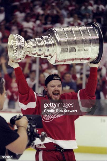 Kris Draper of the Detroit Red Wings holds up the Stanley Cup during the Stanley Cup Finals game against the Washington Capitals at the MCI Center in...
