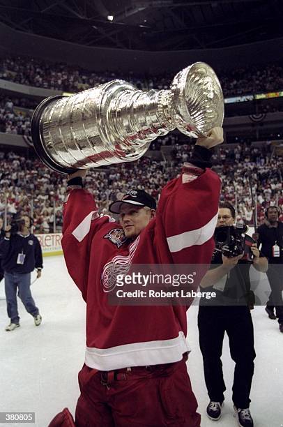 Chris Osgood of the Detroit Red Wings holds the Stanley Cup over his head during the Stanley Cup Finals game against the Washington Capitals at the...