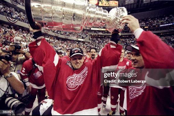 Chris Osgood Of The Detroit Red Wings Holds The Stanley Cup Over His chris-osgood-of-the-detroit-red-wings-holds-the-stanley-cup-over-his