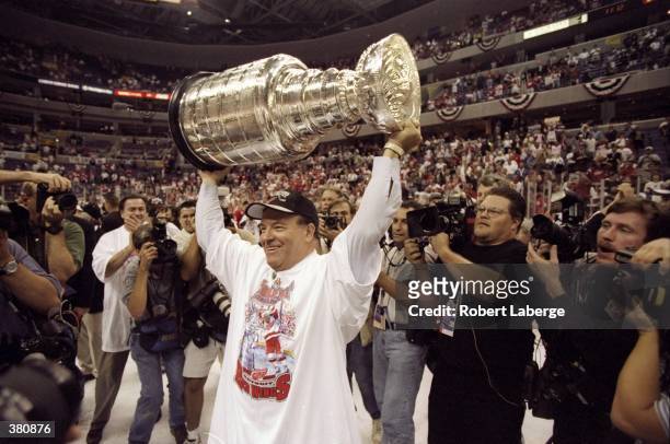 Coach Scotty Bowman of the Detroit Red Wings holds up the Stanley Cup trophy during the Stanley Cup Finals game against the Washington Capitals at...