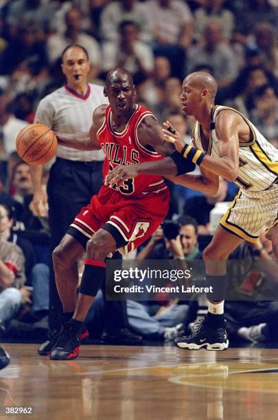 Michael Jordan of the Chicago Bulls dribbles as Reggie Miller of the Indianapolis Pacers guards during the NBA Eastern Conference Finals at the...
