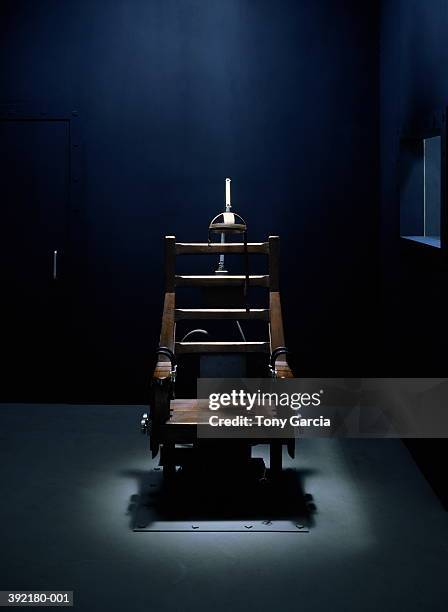 electric chair in dark empty room,  light streaming from above - avrättningsutrustning bildbanksfoton och bilder