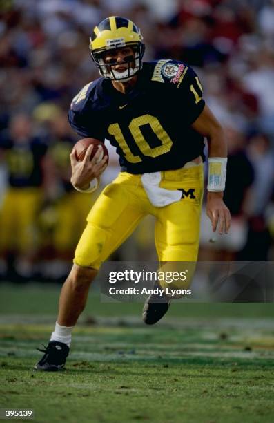 Tom Brady of the Michigan Wolverines carries the ball during the Citrus Bowl against the Arkansas Razorbacks at the Florida Citrus Bowl in Orlando,...