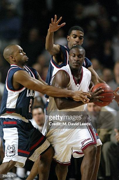 Guard Charlton Clark of the UMass Minutemen in action against guards Ricky Moore and Richard Hamilton of the UConn Huskies during the game at Mullins...