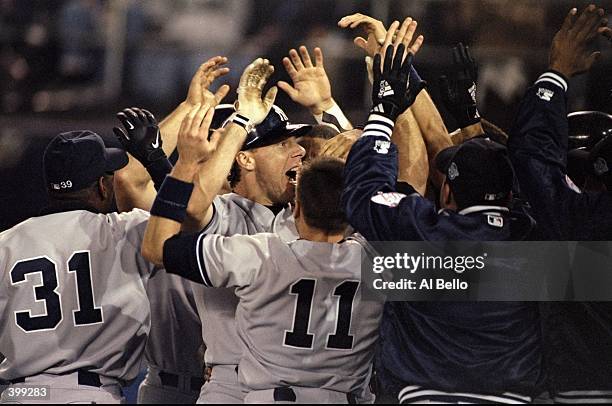 General view as teammates congratulate infielder Scott Brosius of the New York Yankees during the 1998 World Series Game 3 against the San Diego...