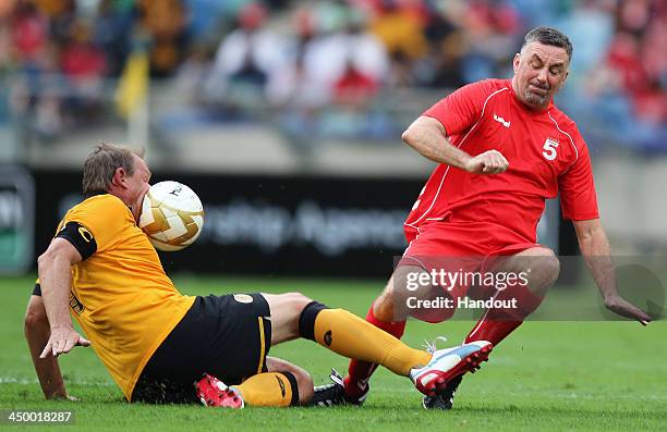 In this handout image provided by the ITM Group, John Aldridge kicks the ball into Neil Tovey during the Legends match between Liverpool FC Legends...