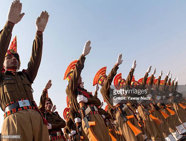 Indian Border Security Force raise their hands a they take oath during their passing out parade on November 16, 2013 in Humhama, on the outskirts of...