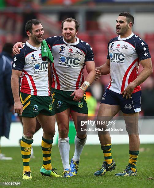 Cameron Smith and Greg Inglis of Australia share a joke with Clint Newton of USA at the final whistle during the Rugby League World Cup Quarter Final...