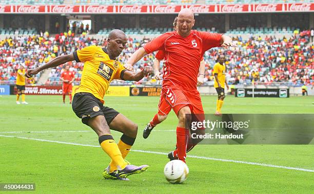 In this handout image provided by the ITM Group, Rob Jones of Liverpool FC Legends tries to stop Arthur Zwane Kaizer Chiefs Legends from crossing the...