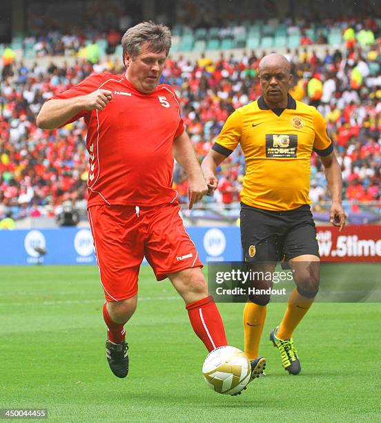 In this handout image provided by the ITM Group, Jan Molby of Liverpool FC Legends and Doctor Khumalo of Kaizer Chiefs Legends during the Legends...