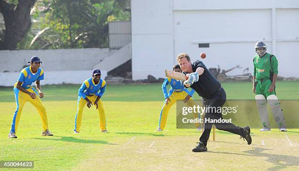 N this handout photo provided by Sri Lankan Government, British Prime Minister David Cameron attempts to bat a ball during his visit to the Colombo...