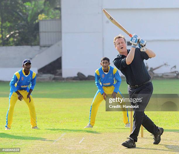 N this handout photo provided by Sri Lankan Government, British Prime Minister David Cameron attempts to bat a ball during his visit to the Colombo...