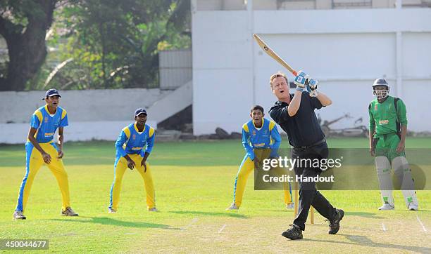 N this handout photo provided by Sri Lankan Government, British Prime Minister David Cameron attempts to bat a ball during his visit to the Colombo...