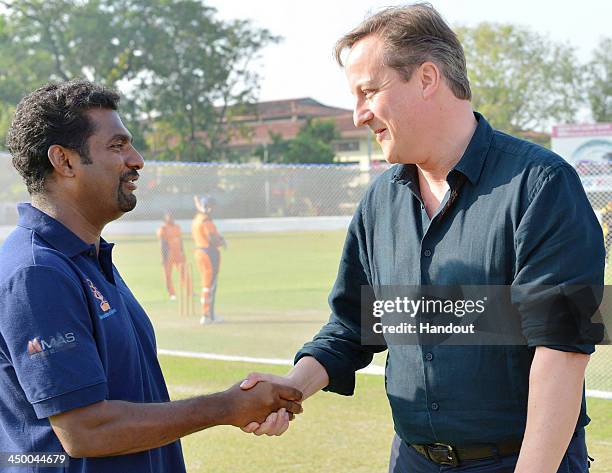 In this handout photo provided by Sri Lankan Government, British Prime Minister David Cameron talks with Sri Lankan spin bowler Muttaiah Muralitharan...