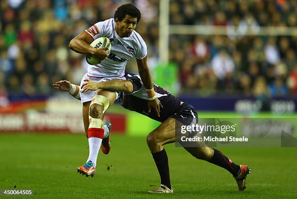 Kallum Watkins of England barges through the challenge of Sebastian Raguin of France during the Rugby League World Cup Quarter Final match between...