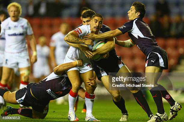 Rangi Chase of England is tackled by Morgan Escare and Mickael Simon of France during the Rugby League World Cup Quarter Final match between England...