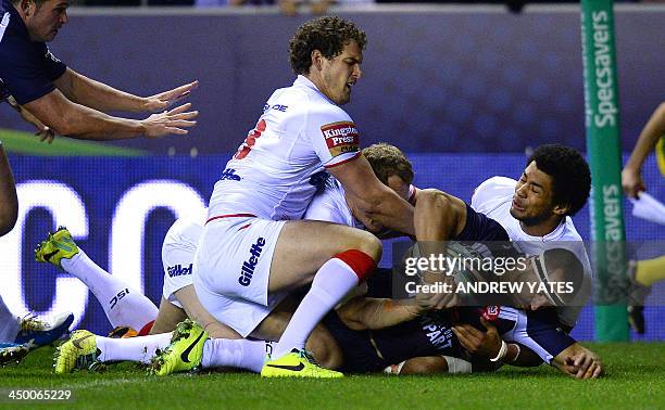 France's Vincent Duport scores the opening try despite the efforts of England's Kallum Watkins and England's Sean O'Loughlin during the 2013 Rugby...