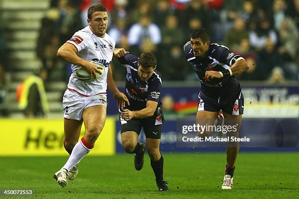 Sam Burgess of England pulls away from William Barthau and Younes Khattabi of France during the Rugby League World Cup Quarter Final match between...