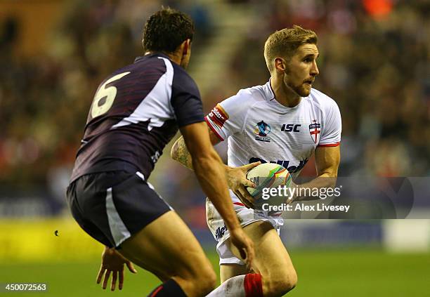 Sam Tomkins of England beats Thomas Bosc of France during the Rugby League World Cup Quarter Final match between England and France at DW Stadium on...