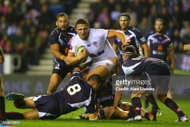 Sam Burgess of England holds off a challenge from Jamal Fakir and Remi Casty of France during the Rugby League World Cup Quarter Final match between...