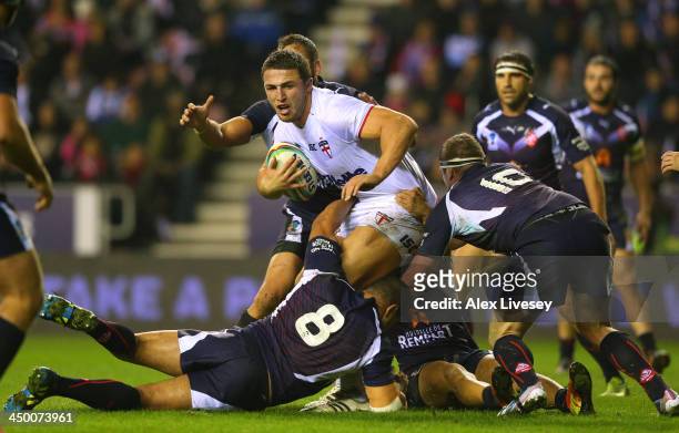 Sam Burgess of England holds off a challenge from Jamal Fakir and Remi Casty of France during the Rugby League World Cup Quarter Final match between...