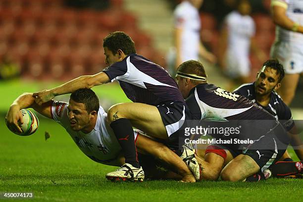Sam Burgess of England is pulled up just short of the try line by Morgan Escare and Remi Casty of France during the Rugby League World Cup Quarter...