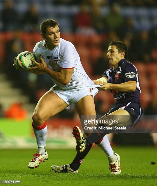 Brett Ferres of England is pulled back by Morgan Escare of France during the Rugby League World Cup Quarter Final match between England and France at...