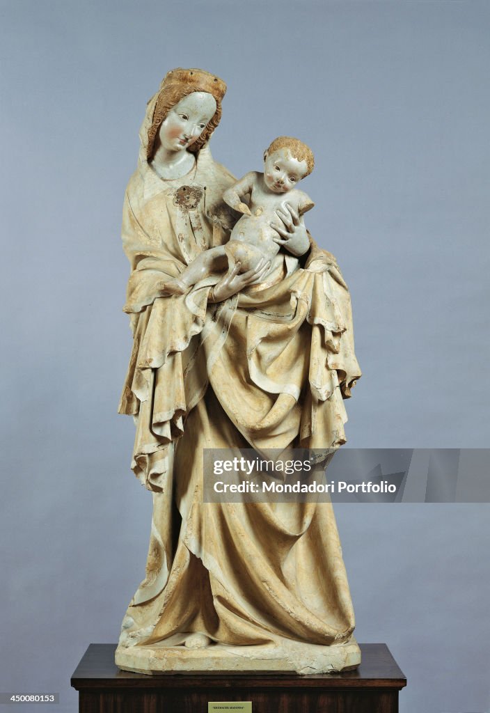 Austria, Vienna, Kunsthistorisches Museum. Whole artwork view. A limestone statuette of the Virgin with the Child, dressed in a wide mantle.