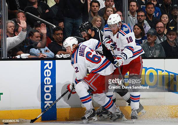 Dwight King of the Los Angeles Kings gets caught at the boards between Carl Hagelin and Marc Staal of the New York Rangers during the third period of...