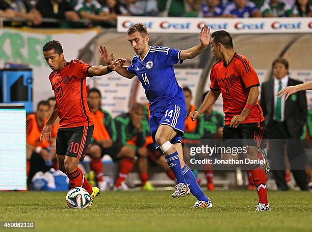 Tino Susic of Bosnia & Herzegovina moves between Giovani Dos Santos and Marco Fabian of Mexico during an international friendly match at Soldier...