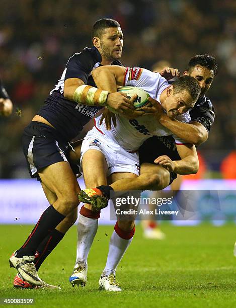 Kevin Sinfield of England is tackled by Eloi Pelissier and Sebastian Raguin of France during the Rugby League World Cup Quarter Final match between...