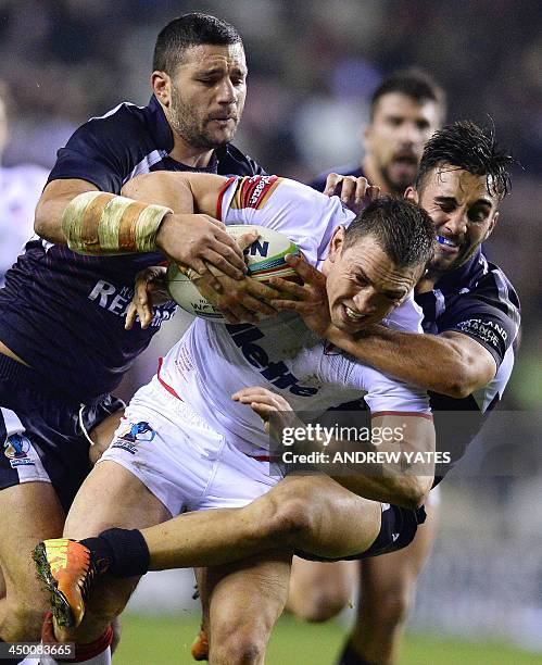 England's Kevin Sinfield is tackled by France's Eloi Pelissier and France's Sebastian Raguin during the 2013 Rugby League World Cup quarter-final...