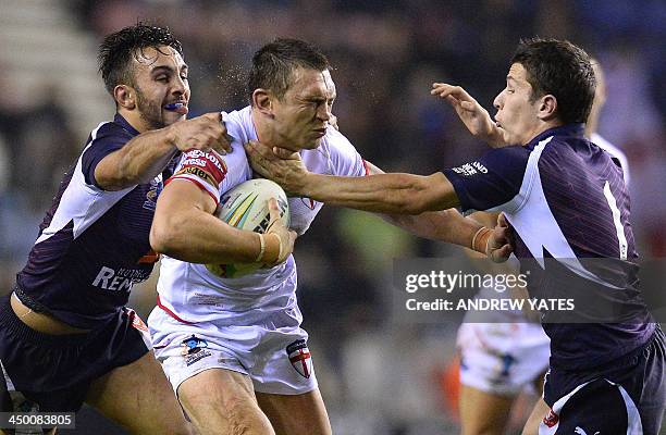 England's Kevin Sinfield is tackled by France's Morgan Escare and France's Eloi Pelissier during the 2013 Rugby League World Cup quarter-final match...