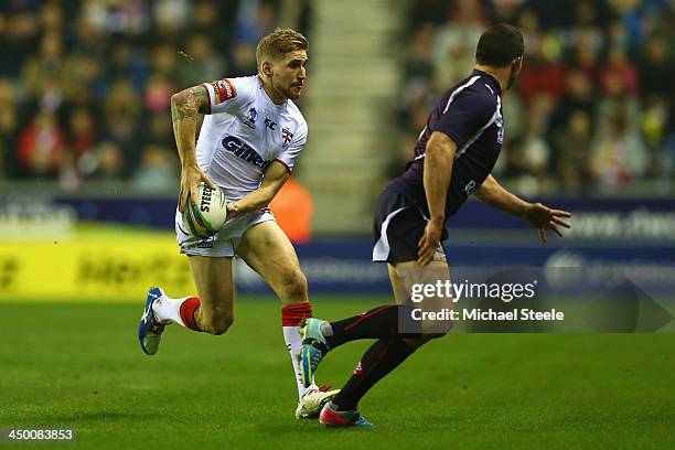 Sam Tomkins of England looks to offload during the Rugby League World Cup Quarter Final match between England and France at the DW Stadium on...