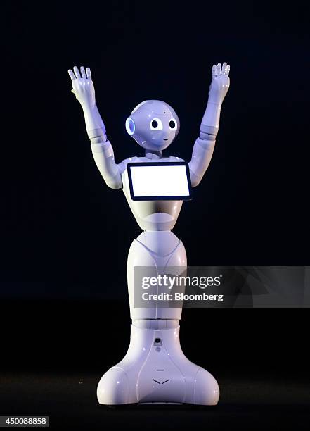 Human-like robot called Pepper, developed by SoftBank Corp.'s Aldebaran Robotics unit, raises it's arms during a news conference in Urayasu, Chiba...