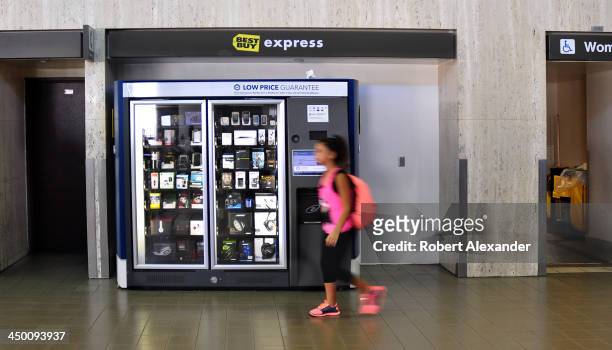 Young airline passenger passes a Best Buy Express kiosk at Los Angeles International Airport. The quick-serve kiosks are stocked with an assortment...