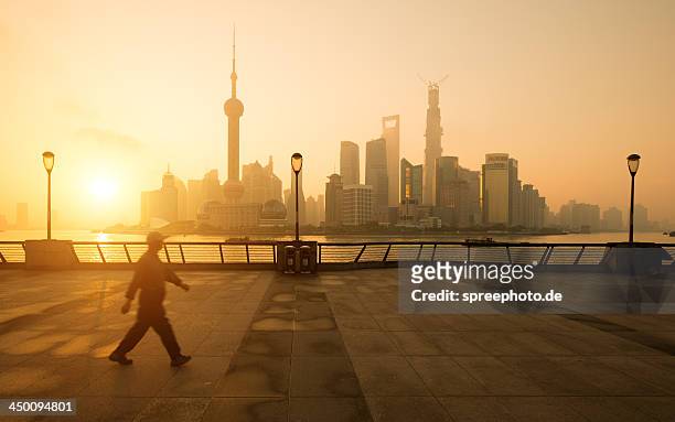 sunrise on bund shanghai with walking man - bund uferpromenade stock-fotos und bilder