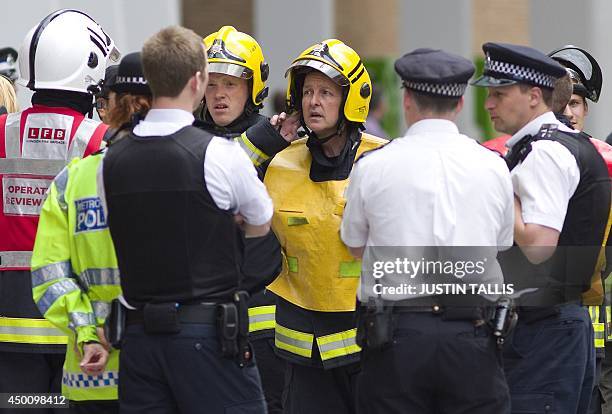 Fire crews talk with police personnel outside the Shard building in central London on June 5 following an evacuation of the building after reports of...